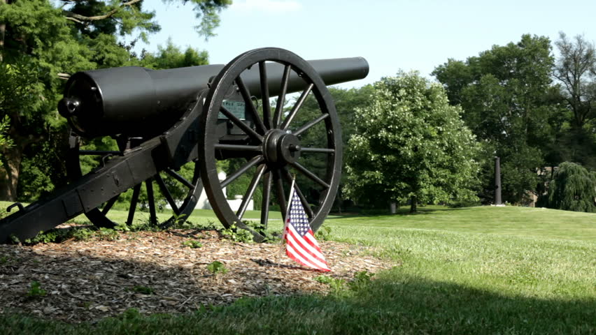 Civil war Artillery Canon sitting next to American flag.