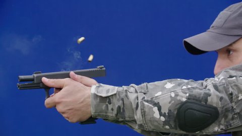 Man with a gun training on chroma key blue screen background