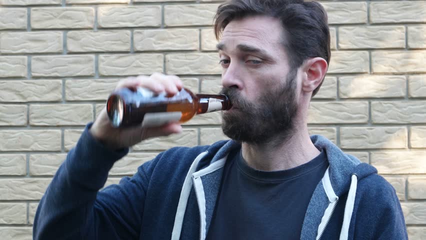 man in front of brick wall drunk
