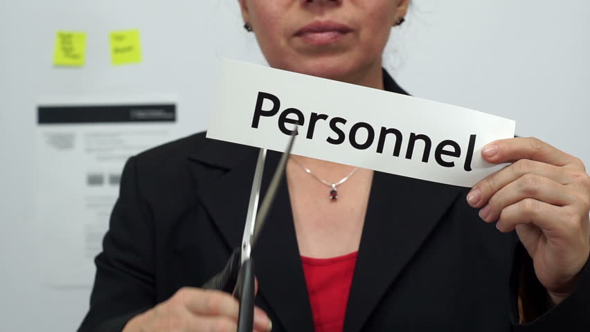 Female office worker or business woman cuts a piece of paper with the word personnel on it as a personnel reduction business concept. | Shutterstock HD Video #17679079