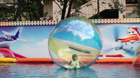 MOSCOW, RUSSIA - JULY 29, 2015: Kids in zorb bubble ball swimming in pool
