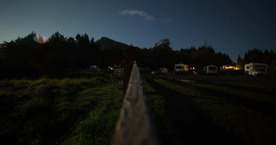 Tongue Point, Washington, USA - starry night with moonlight and moving shadows on the campground with illuminated camper vans - Timelapse with zoom in - October 2014