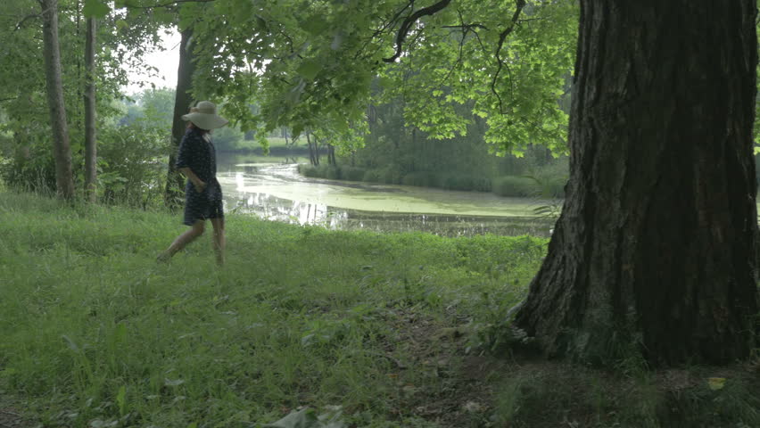 A woman in a hat at the lake in the Park