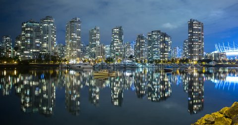 Vancouver, British Columbia, Canada - view over False Creek, Quayside Marina, Cambie Street Bridge and illuminated BC Place Stadium at night - Timelapse with pan left to right