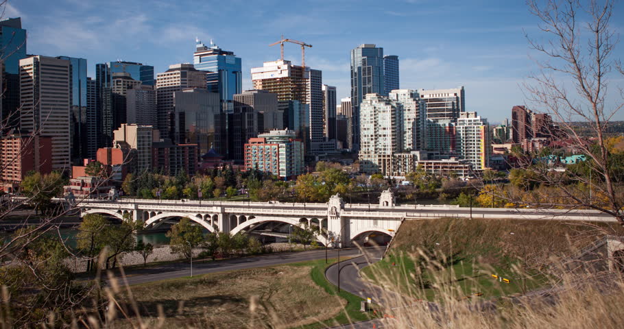 Calgary, Alberta, Canada - view at Commercial Downtown and Centre Street Bridge from Samis Road NE over Bow River at a sunny day - Timelapse with motion and zoom out