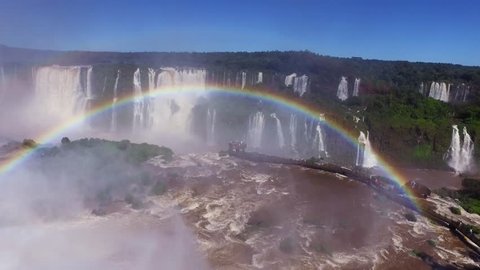 Beautiful Rainbow formed in front of the Iguazu Falls on the Brazil and Argentina border in 4k. Pan across the waterfalls from a viewing platform