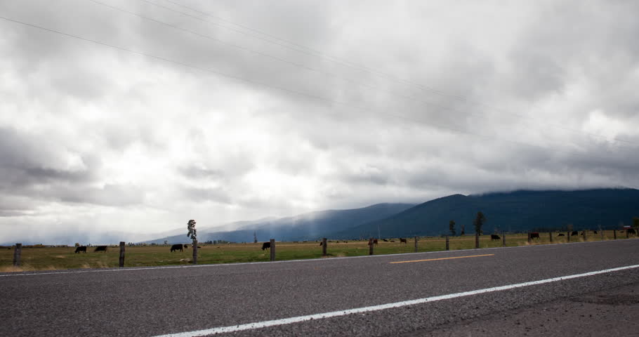 Fort Klamath, Oregon, USA - Volcanic Legacy Scenic Byway to the Crater Lake with cows in the meadows, moving clouds and sunbeams - Timelapse with motion and zoom out - October 2014