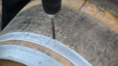 man drill wine barrel with electric drill