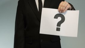 Businessman shows printed question and check mark. - Powered by Shutterstock - Get 15% off with code: PIKWIZARD15