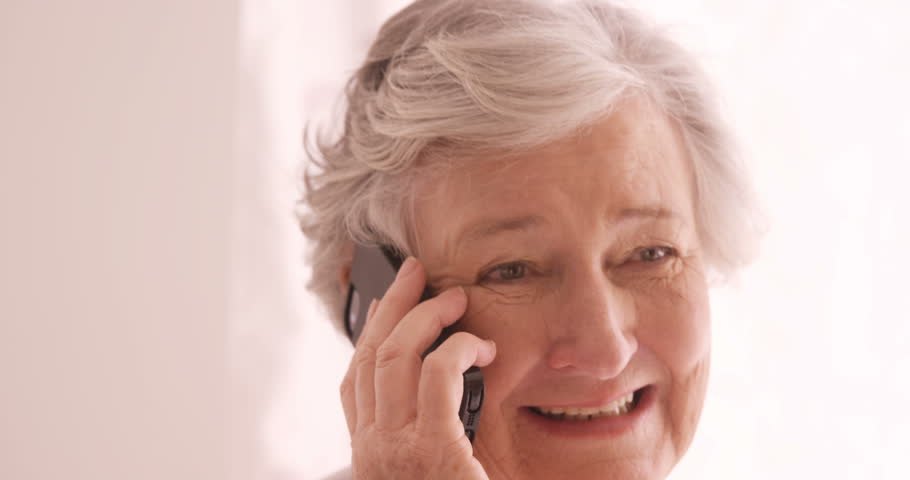 Senior Caucasian woman talking on mobile phone at home