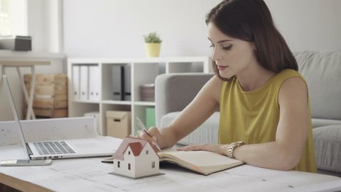 Female architect working from home over some bluerprints