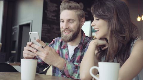 Attractive young couple taking selfie at restaurant, cafe