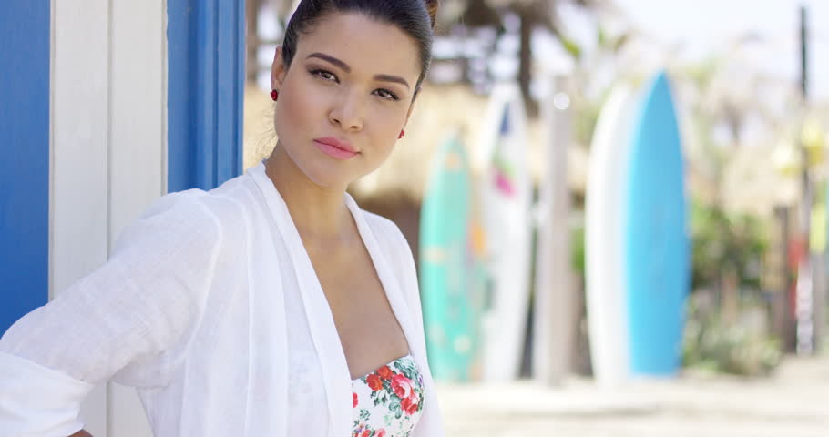 Happy woman in bathing suit in front of surfboards