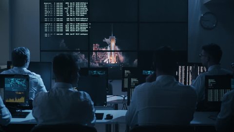 Group of People in Mission Control Center filled with Displays, Celebrating Successful Rocket Launch. Elements of this image furnished by NASA. Shot on RED Cinema Camera in 4K.