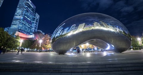 Chicago, Illinois, USA - view of Cloud Gate "the bean" with reflections of illuminated skyline at Millennium Park at night with a few clouds - Timelapse with motion and zoom out