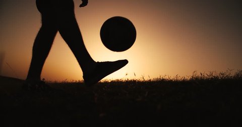 football player silhouette , practicing with the ball,the sunset Golden hour,close-up feet, slow motion Video Stok