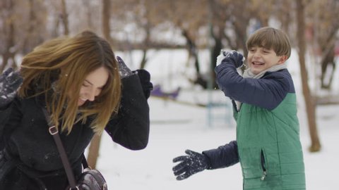 Happy family playing snowballs. Shot on RED EPIC Cinema Camera in slow motion.