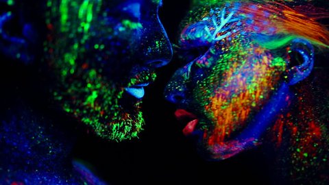 People are colored fluorescent powder. Unreal love in ultraviolet light.