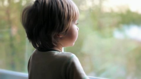 Caucasian  cute baby boy kid toddler child looking out the window Video de stock