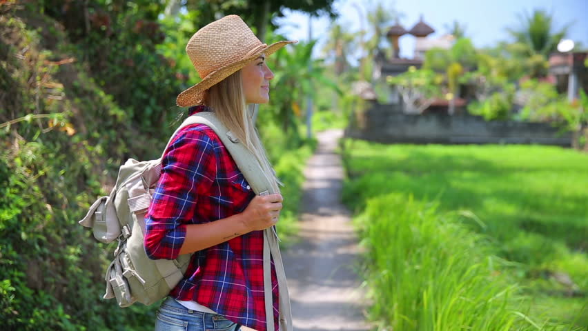 Beautiful girl traveling with backpack, wearing straw hat, standing and looking around, enjoying beautiful nature of Asia. Full HD Video 1920x1080