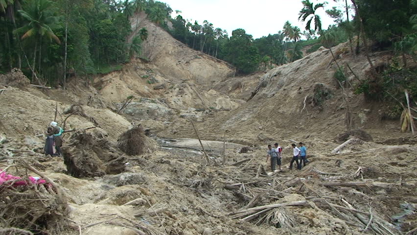 PADANG, INDONESIA - CIRCA OCTOBER 2009: Survivors stand on remains of village