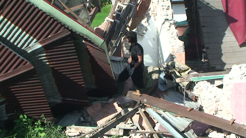 PADANG, INDONESIA - CIRCA OCTOBER 2009: Men repair heavily earthquake damaged