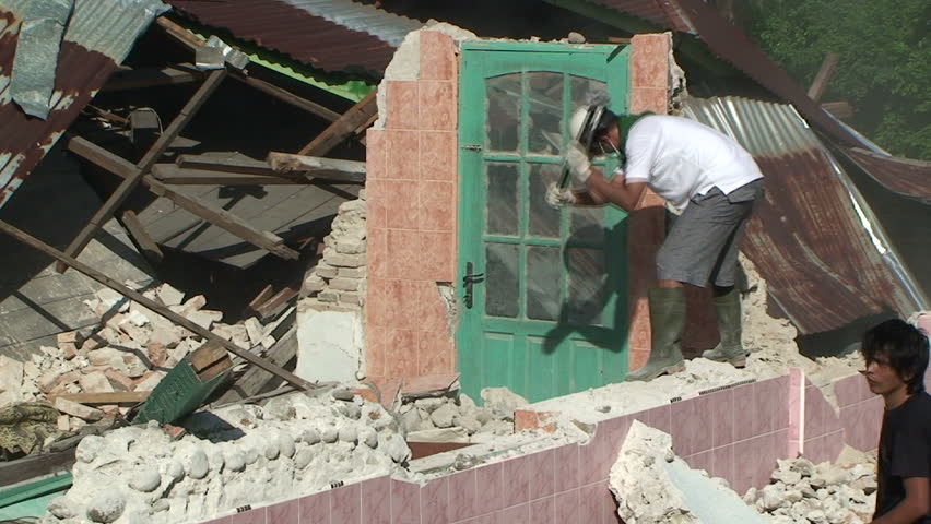 PADANG, INDONESIA - CIRCA OCTOBER 2009: Men repair heavily earthquake damaged