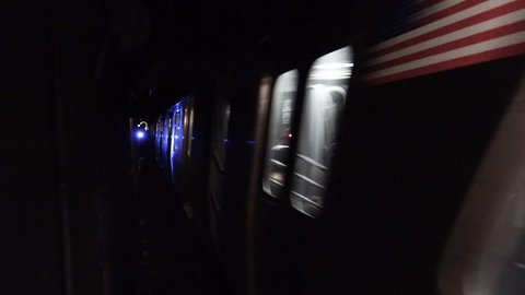 Loop of subway moving through dark tunnel. Loopable inside subway tunnel with blue traffic signal light. Blurry train moves through underground railway in restricted area for people.