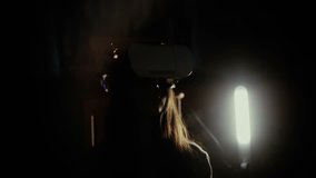 Woman using VR-helmet in the spotlight