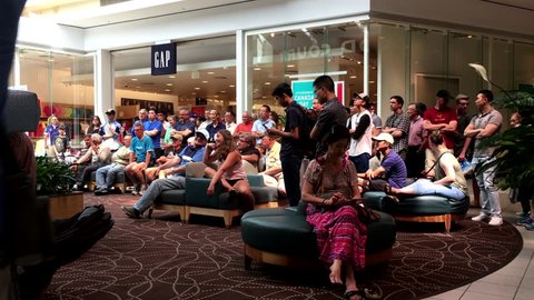 Coquitlam, BC, Canada - July 01, 2016 : Motion of mall resting area with people surrounding for watching football game.