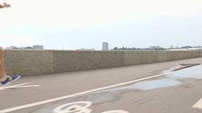 Man in blue uniform running along embankment. Steadicam 4K video