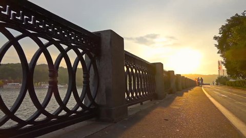 Man running on summer sunset embankment along bicycle road, Moscow. Super slow motion steadicam shot at 240 fps