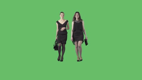 Two beautiful young women in black formal dresses are walking at the camera. Camera is static. Lens 85 mm. Footage with alpha channel. File format - .mov, codec PNG+Alpha