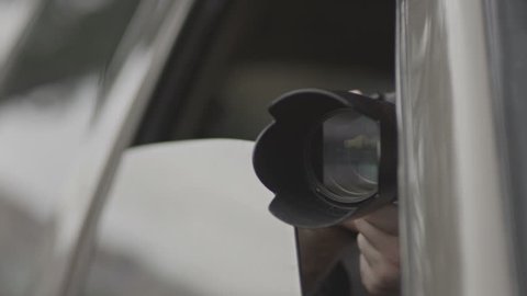 Spy, paparazzi or detective in the car,shooting on camera. 