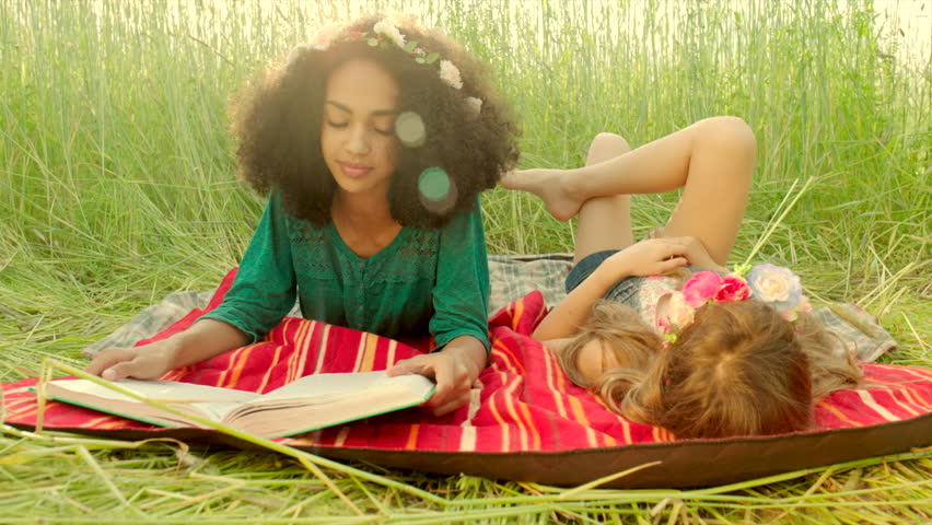 Young girls lying on cover and reading