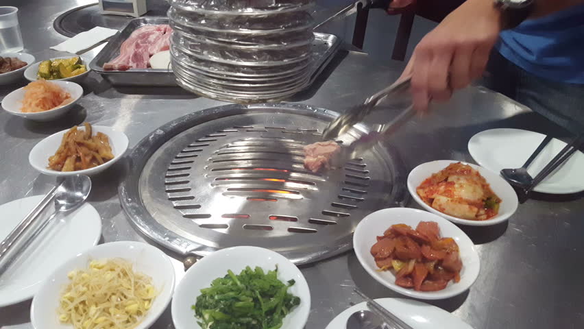 Hands cooking for a group of friends to eat barbecue