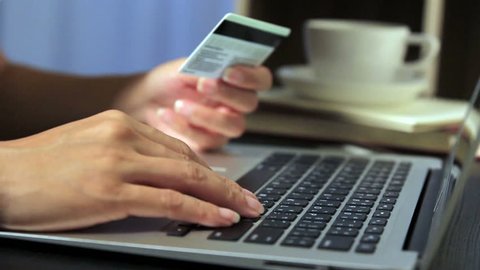 Woman using credit card with laptop hopping online