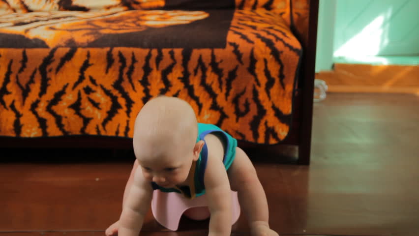 Smiling child sitting on chamber pot indoors. Trying to get out of the pot