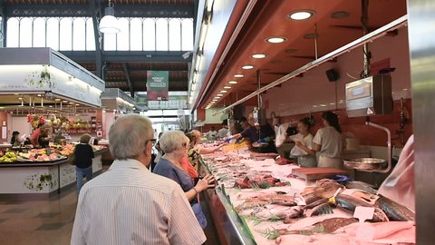 BARCELONA, SPAIN - CIRCA 2016: People buying frensh fish and crabs from market stall in the famous Mercat de la Llibertat in central Barcelona, Spain