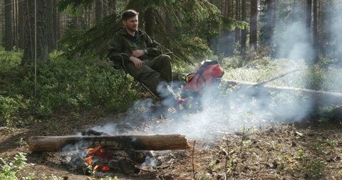 a man sits at a campfire