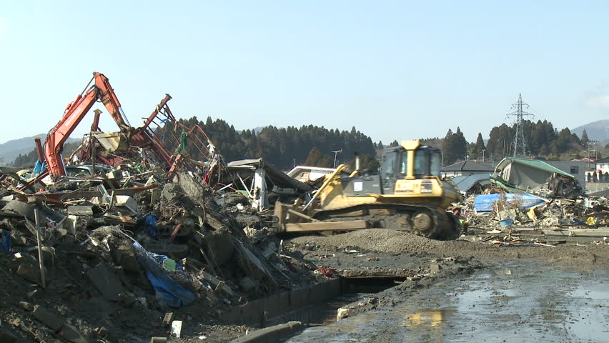 KESENNUMA, JAPAN - CIRCA APRIL 2011: Heavy machinery moves through tsunami