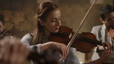 4K Close-up of musician playing violin on the symphony hall. Shot on RED EPIC Cinema Camera in slow motion.