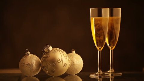 Christmas ornaments and two glasses of A1:AK1130 in front of a glittering background which is turning bright and dark alternatively.