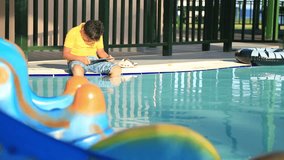 Young boy using digital tablet near the pool