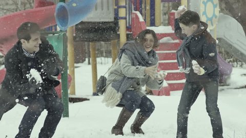 Happy family playing snowballs in the garden. Shot on RED EPIC Cinema Camera in slow motion.