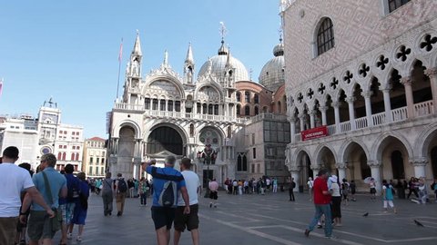 VENICE ITALY - CIRCA JUNE 2011: Spectators and tourists visit famous St Marks Square cathedral and Doges Palace Ducale in Venice Italy