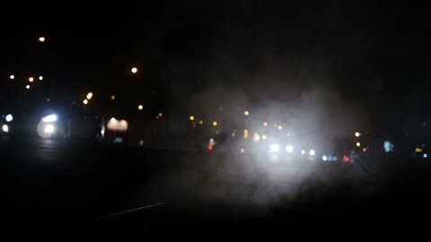 Night movement of cars and steam from the sewer