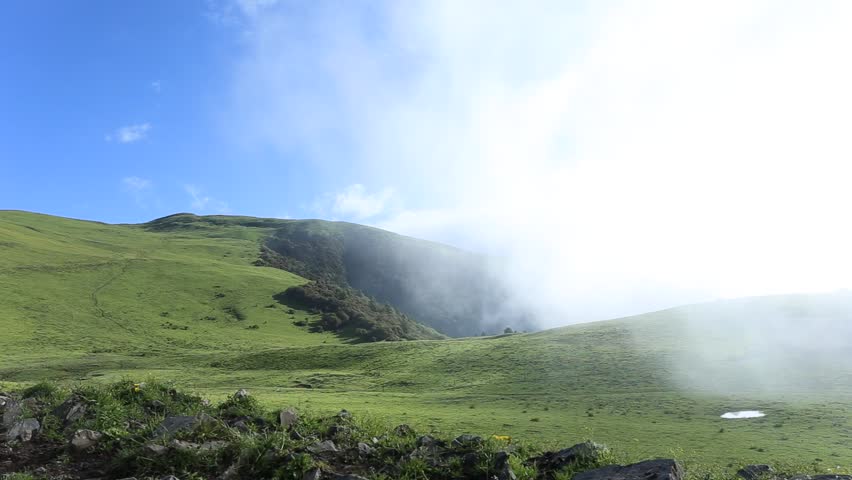 Fast moving clouds rising from the valley, on the beautiful high mountain grassland