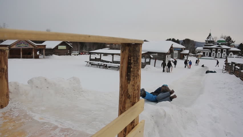 People ride from icy mountain in old ecovillage.