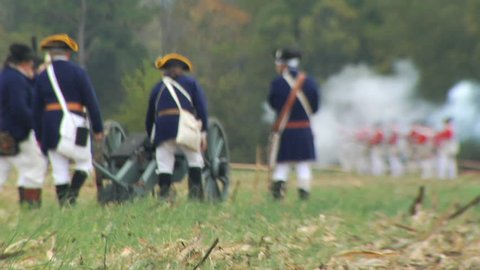 VIRGINIA - OCTOBER 2014 - Reenactment, large-scale, epic American Revolutionary War anniversary recreation -- in the middle of battle.  Cannons fire with British Redcoats and Continental Soldiers.
